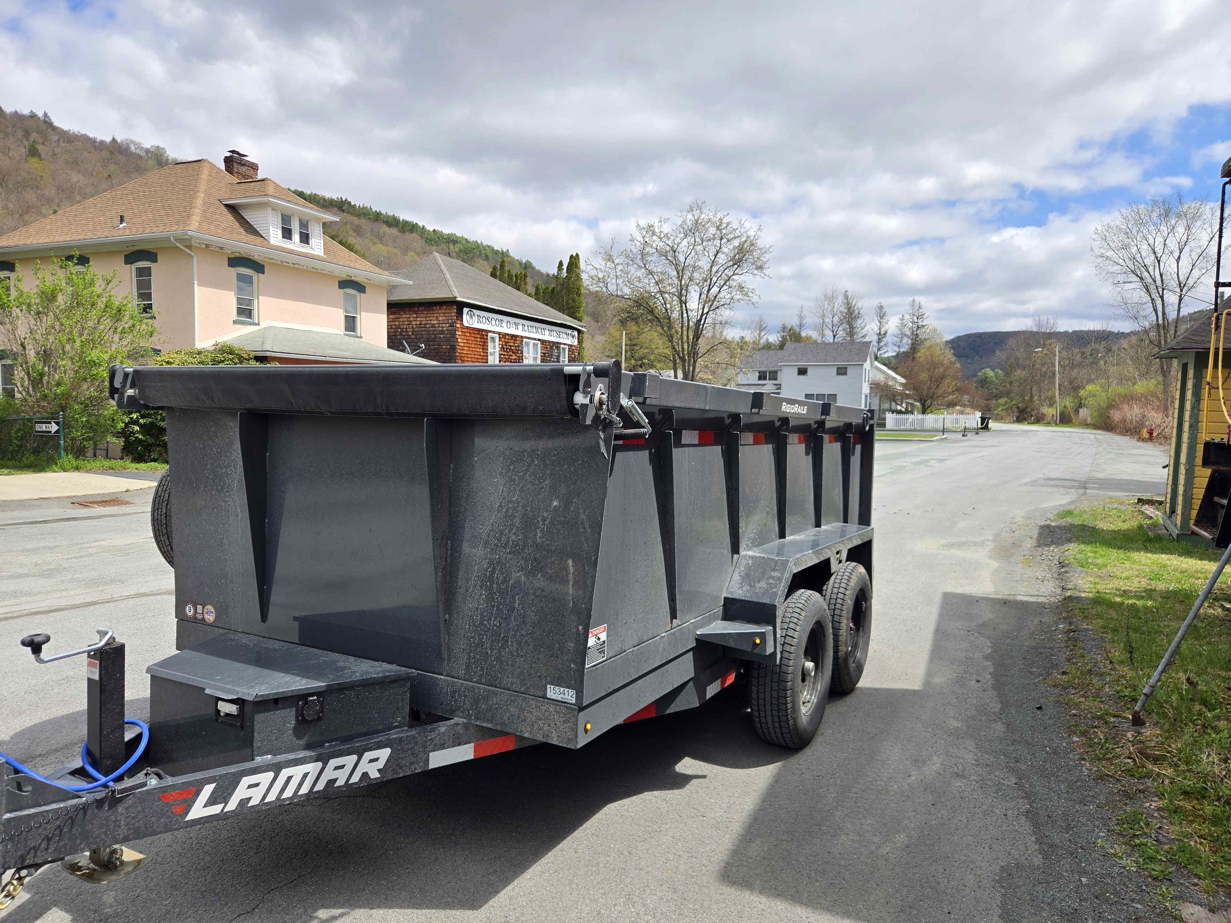 Grey hydraulic dump trailer for rent in Poughquag, NY - perfect for landscaping and construction debris removal
